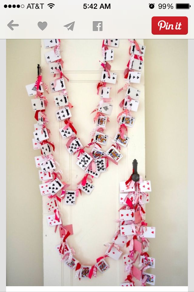 a number of cards attached to a door with clothes pins and ribbons hanging from them