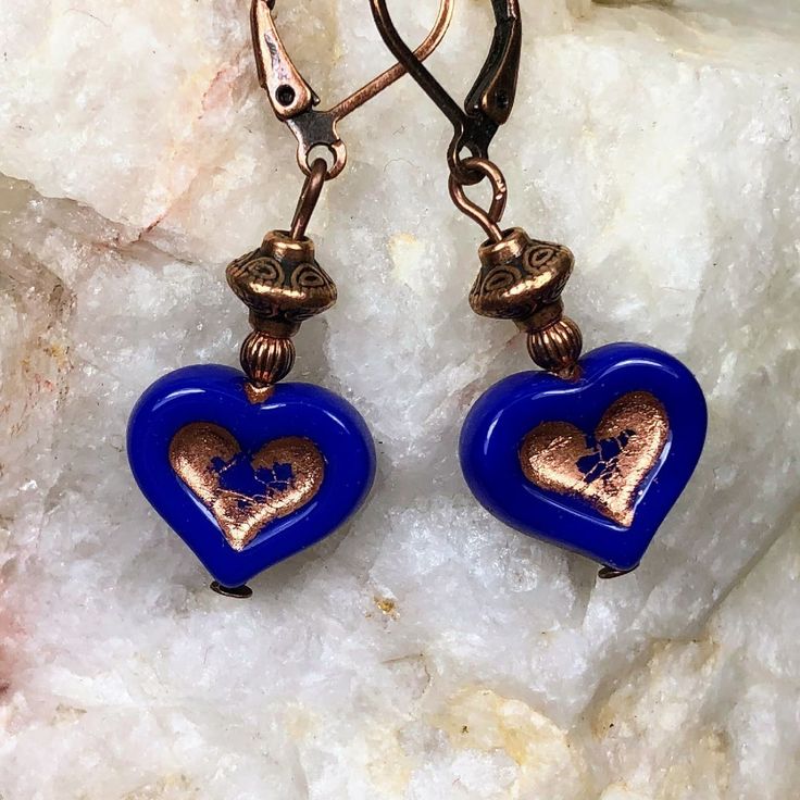 Royal blue Czech glass heart beads with copper inlays dangle from copper beads. These heart earrings are very versatile, lightweight and comfortable for all day wear.  Design is on both sides of the 3-D heart charm. Artisan glass beads produced in small quantities in Czech Republic  Hypoallergenic ear wires (nickel and lead free). Select ear wire style at checkout. A gift for you or someone special, earrings are carded and in an organza bag. Link back to my shop: https://www.etsy.com/shop/JezaJewelry Royal Blue Heart Czech Glass Earrings  - Bohemian Jewelry -  Handmade Gift for Her - Valentine's Day Gift Blue Heart Charm Drop Earrings, Blue Heart Bead Earrings, Blue Heart-shaped Drop Earrings For Gifts, Blue Heart-shaped Earrings With Heart Beads, Blue Heart Earrings For Valentine's Day, Blue Earrings For Anniversary On Valentine's Day, Elegant Blue Earrings For Valentine's Day, Blue Heart Charm Earrings For Valentine's Day, Nickel-free Blue Heart Earrings