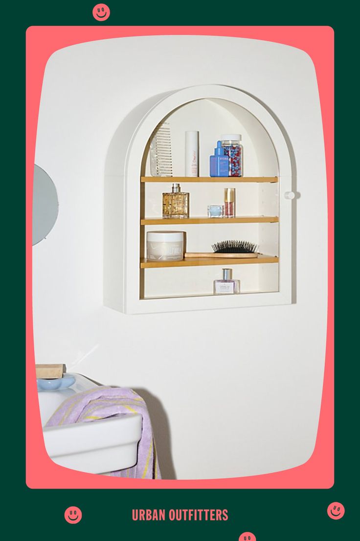 an arched window in the wall above a shelf