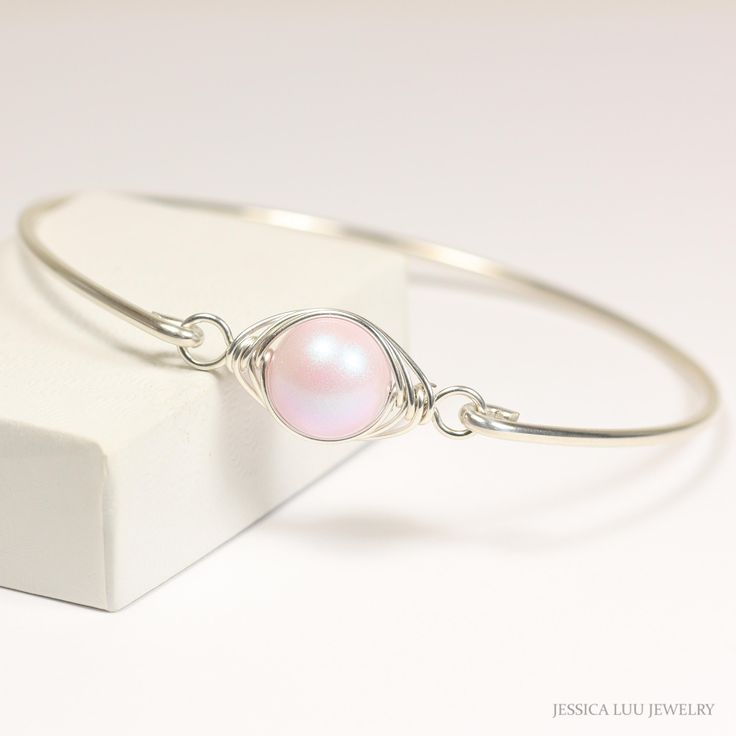 Wire Wrapped Dreamy Rose Pearl Bracelet Handmade by Jessica Luu Jewelry ~ Sophisticated ~ Ladylike ~ Elegant ~ Perfect for everyday wear, this bangle adds a touch of casual elegance to every occasion - available in 3 metal choices.  A bangle has no closure and must be slid over your hand, so please use your hand size not wrist size to measure against the size chart below. MATCHING ITEMS https://www.etsy.com/shop/JessicaLuuJewelry?search_query=dreamy+pink MATERIALS: ~ 10mm dreamy rose crystal nacre pearl ~ Sterling silver or 14K gold filled wire ~ Gold filled wire is a hollow tube of 14 karat gold that is filled with brass for durability, so all the metal outside is 14K gold; gold filled wire will not wear off like gold plating and will last a lifetime. WANNA SEE MORE? Visit JessicaLuuJewel Elegant Adjustable Pink Bracelet, Elegant Pink Jewelry Hand Wrapped, Elegant Hand Wrapped Pink Jewelry, Elegant Pink Hand Wrapped Jewelry, Wire Wrapped Pearl Bracelet Gift, Pink Hand-wrapped Bangle Jewelry, Pink Hand Wrapped Bangle Jewelry, Hand Wrapped Pink Bangle Jewelry, Delicate Pink Round Bracelets