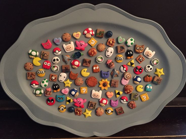 there are many different buttons in the tray on the table, including one that is shaped like an animal