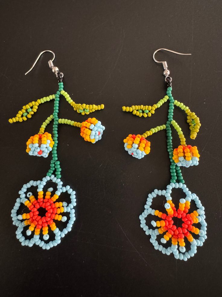 Here we have a beautiful pair of Floral hand crafted earrings! Handmade Flower Earrings For Festival, Handmade Unique Beaded Earrings, Handmade Traditional Flower Earrings, Flower-shaped Festival Earrings With Dangling Beads, Flower Shaped Festival Earrings With Dangling Beads, Bohemian Single Flower Earring, Unique Flower-shaped Earrings For Festival, Traditional Flower-shaped Earrings With Ear Wire, Unique Flower Shaped Beaded Earrings With Ear Wire