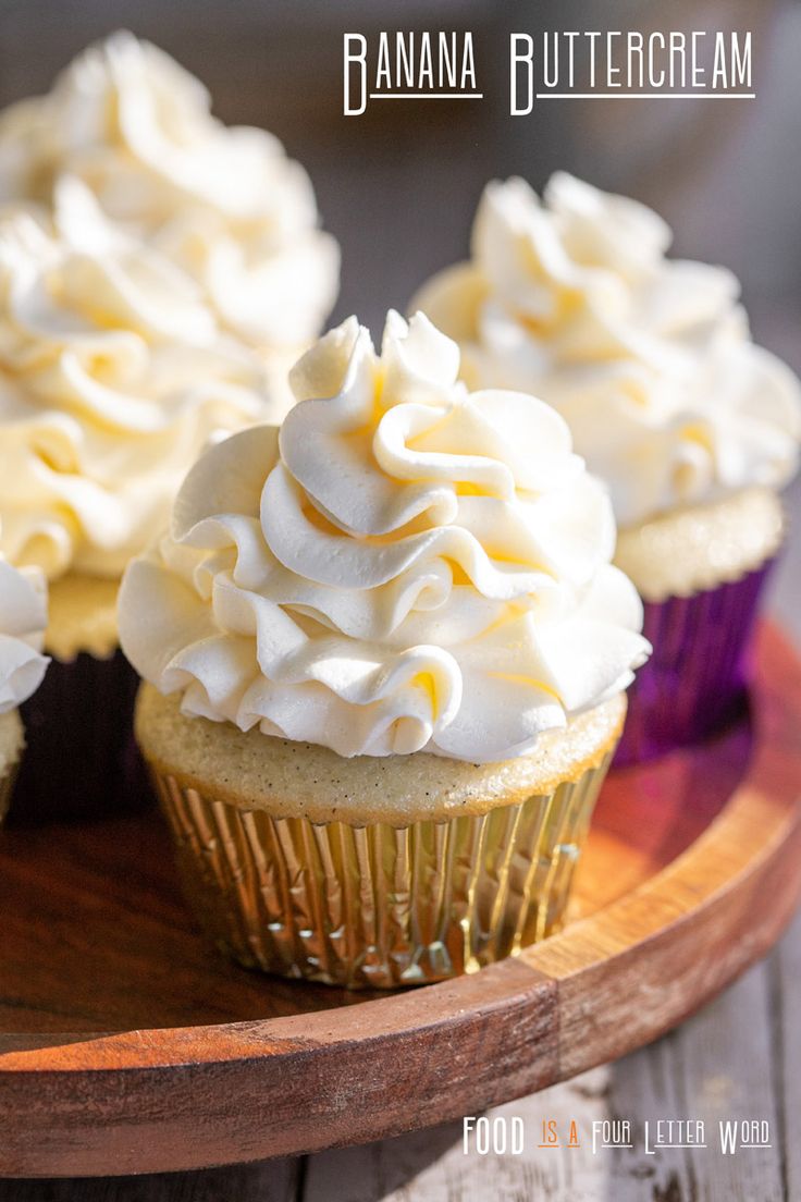 several cupcakes with white frosting on a wooden plate and the words banana buttercream above them