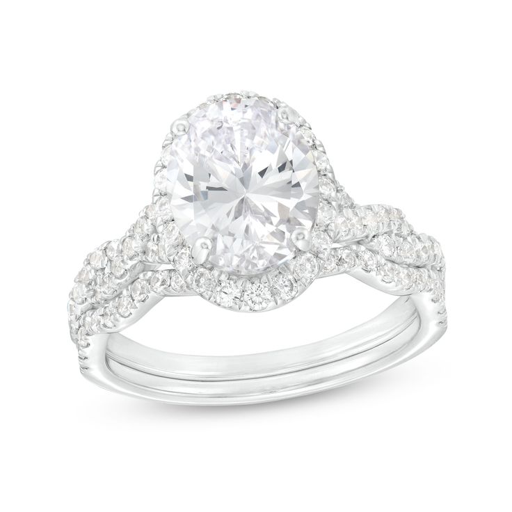 a white gold engagement ring set with an oval cut diamond surrounded by pave diamonds