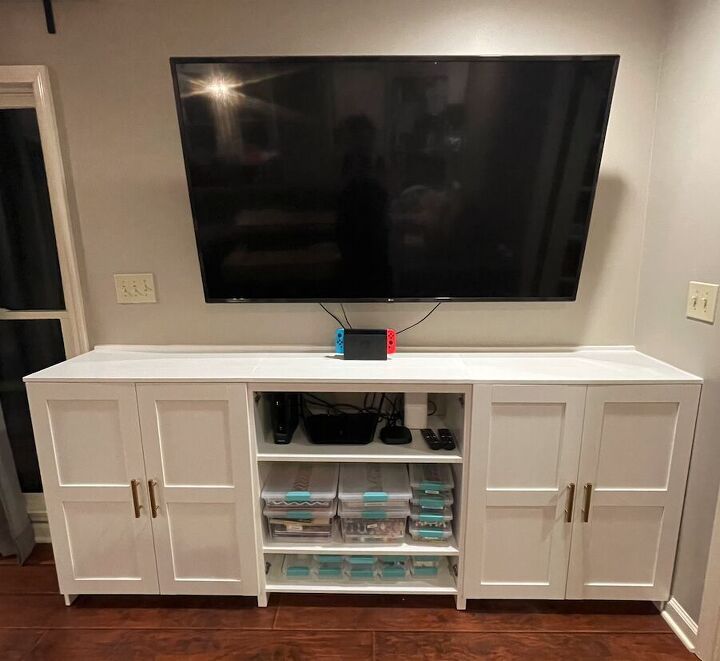 a flat screen tv mounted to the side of a white entertainment center in a living room