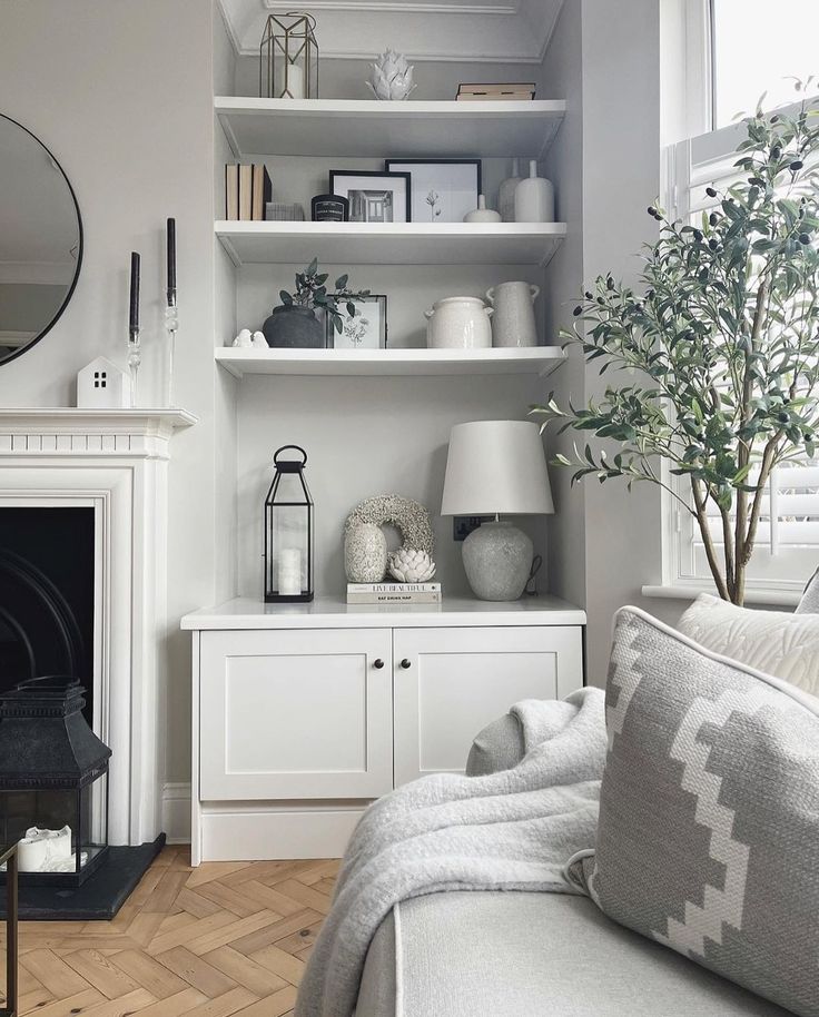 a living room filled with furniture and a fire place in front of a mirror on the wall