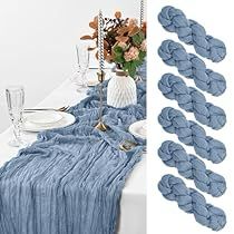 there are many blue yarns laid out on the table next to glasses and flowers