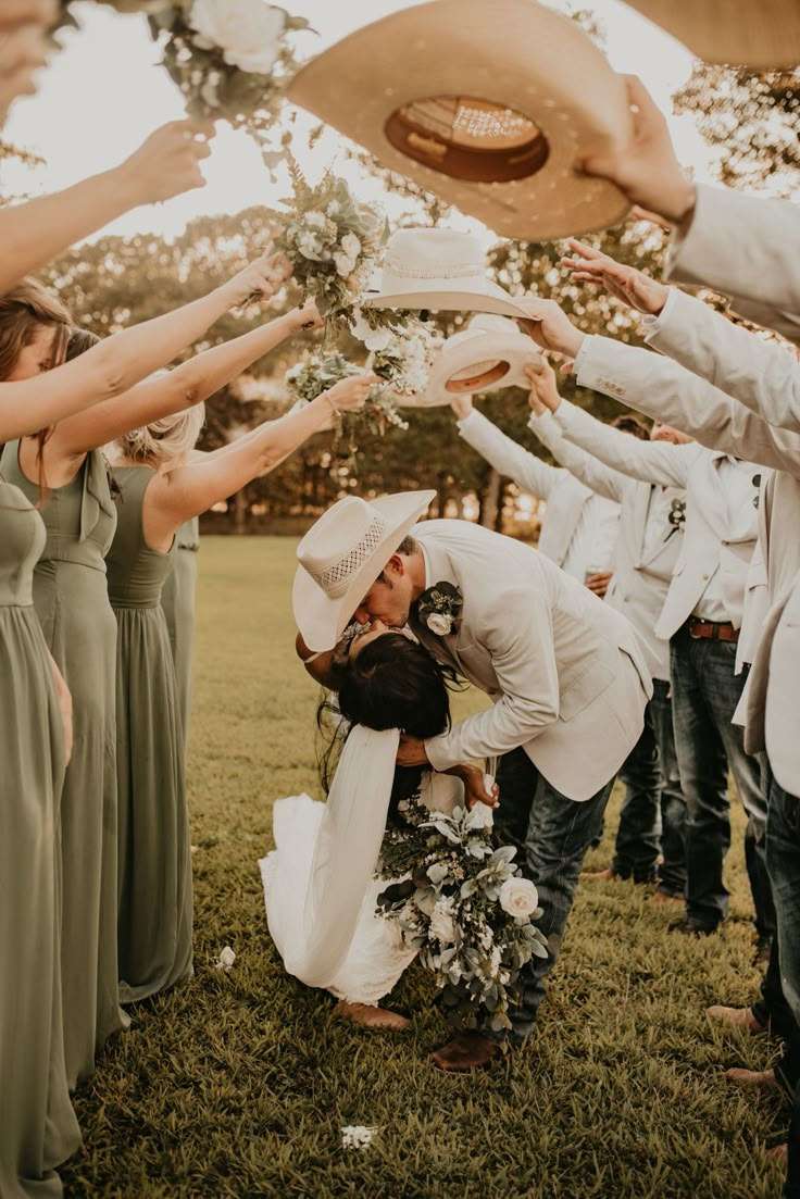 a group of people standing around each other with hats on their heads and hands in the air