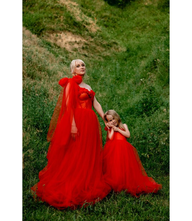 two women in red dresses posing for a photo