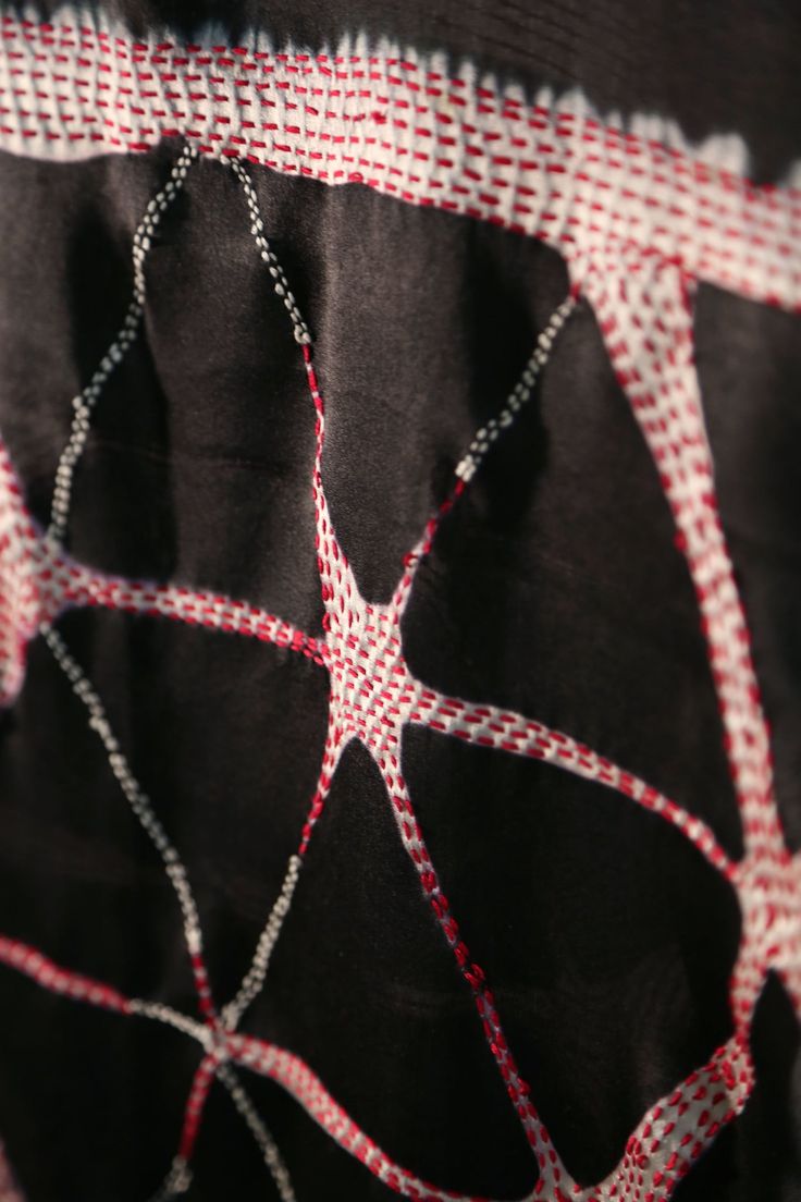 the fabric has been stitched together and is black with red lines on it,