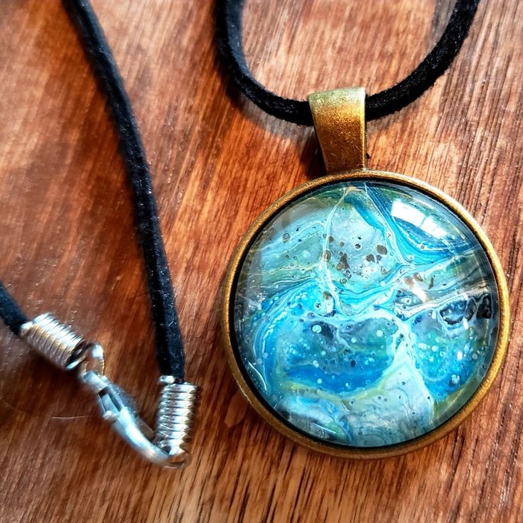 One Of A Kind Handmade Acrylic Pour/Fluid Art Necklace Pendant With Black Cord. The Color In The Pendant Are Different Shades Of Blue And Green. The Colors Shimmers In The Sun Light. Would Make A Perfect Gift For The Holidays The Ditzy Gypsy On Poshmark Is A Curated Boutique For Anyone Who Wants To Make A Statement With Their Style. We Offer Brand New, Like New And Pre Owned Clothing. The Ditzy Gypsy On Poshmark Offers You Clothes That Will Always Be One Of A Kind - Just For You! Our Prices Are Blue Round Pendant Necklace, Adjustable Blue Round Pendant Necklace, Blue Necklace With Round Pendant, Adjustable, Artistic Turquoise Necklace With Round Pendant, Artistic Blue Jewelry With Large Pendant, Artsy Nickel-free Necklace With Round Pendant, Artistic Adjustable Round Necklace, Artistic Round Adjustable Necklaces, Artistic Adjustable Nickel-free Necklace