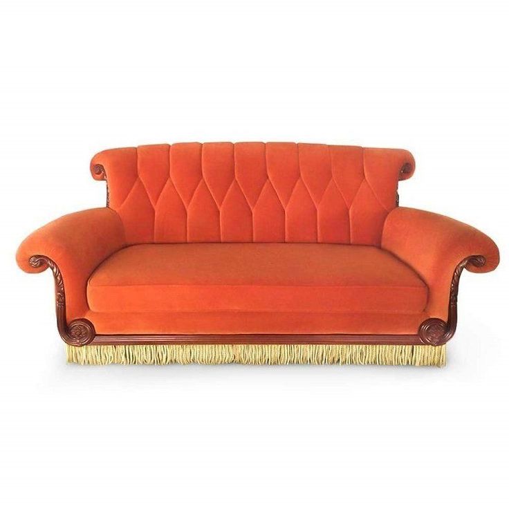 an orange couch with gold trim and fringes on the legs, sitting in front of a white background