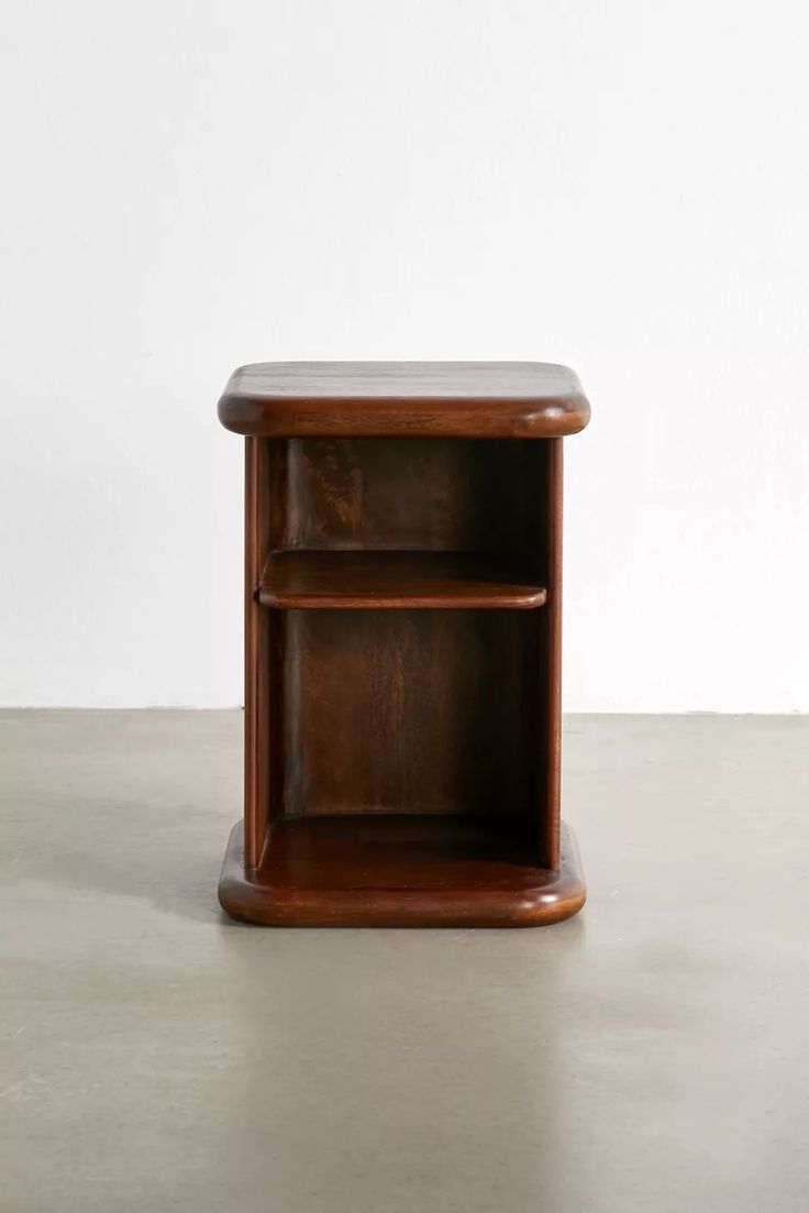 a wooden shelf sitting on top of a cement floor