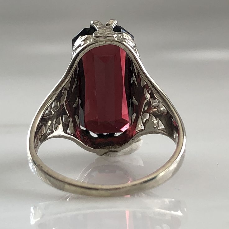 Details: Stunning Edwardian Period garnet and 14K white gold filigree ring! The stone measures 14.5mm by 7mm, and the is 4.6mm above the finger at the highest point on the ring. The filigree is beautiful on this ring, and is in lovely shape. This is a stunning ring--you will not be disappointed! Please ask all necessary questions prior to placing an order. Measurements: The size is 4 1/2 US and can be sized for a fee. Condition: The overall all condition of this ring is very good. Ornate Red Hallmarked Filigree Ring, Red Vintage Filigree Ring With Gemstone, Formal Red Garnet Filigree Ring, Ornate Red Filigree Ring, Hallmarked, Red Victorian Filigree Ring With Gemstone, Filigree Ring Gold, Garnet Gem, 14k Rose Gold Ring, Red Band