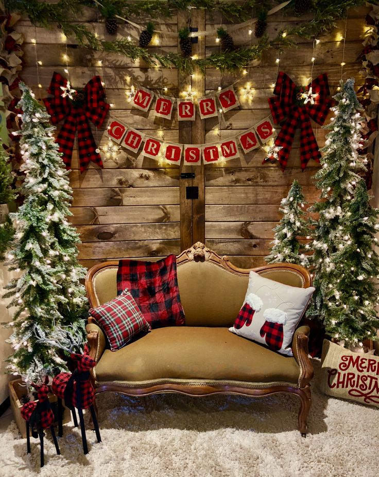 a living room decorated for christmas with plaid and red decorations on the walls, trees and garlands