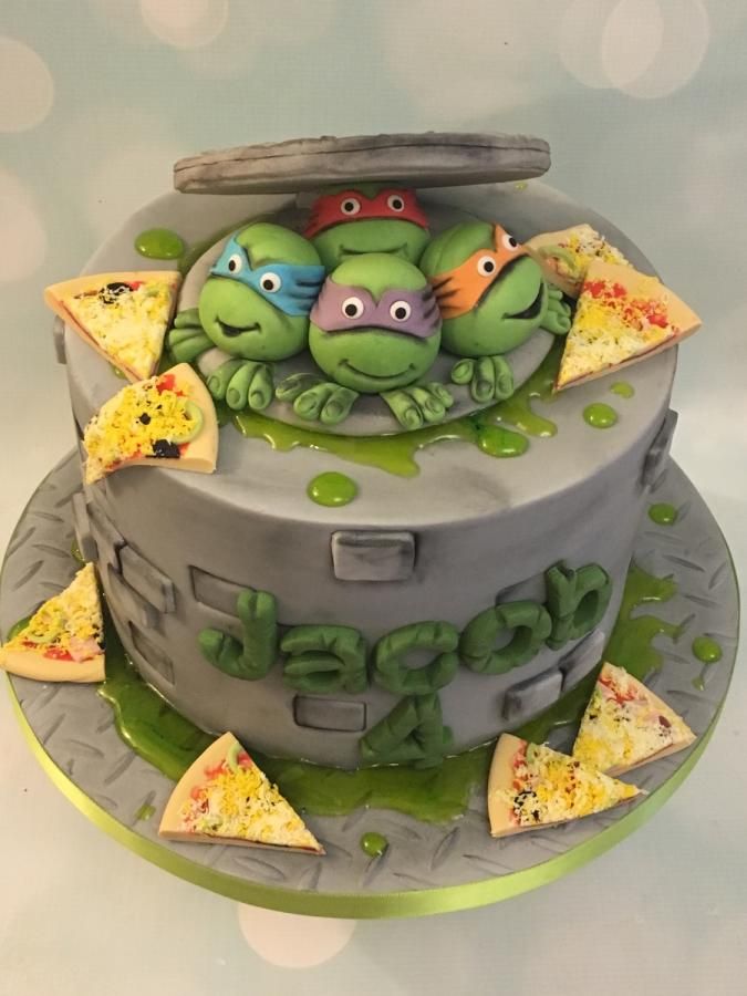 there is a cake decorated to look like a turtle and two pizza slices on it