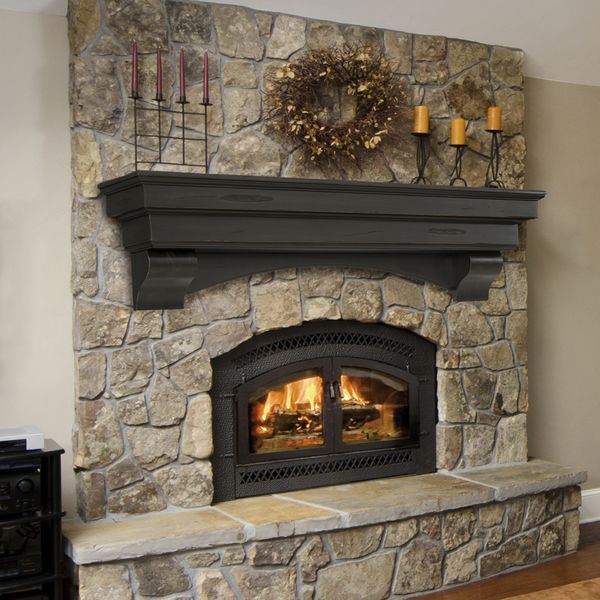 a living room with a fire place in the center and a wreath on the mantle