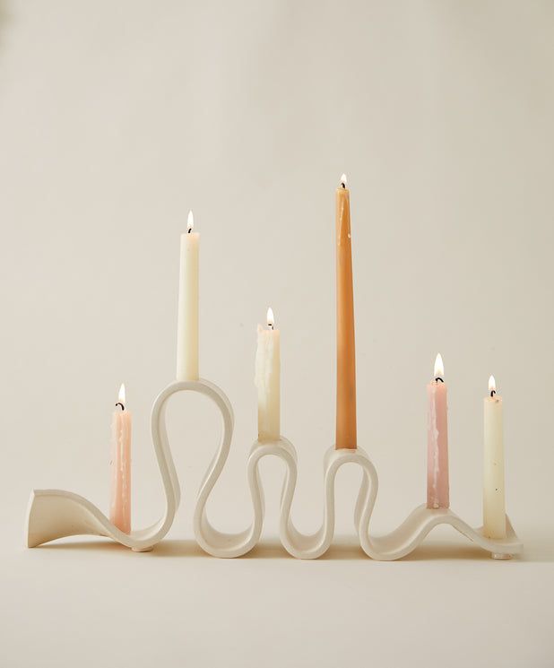 five candles are lined up in the shape of an x, with one candle on each side