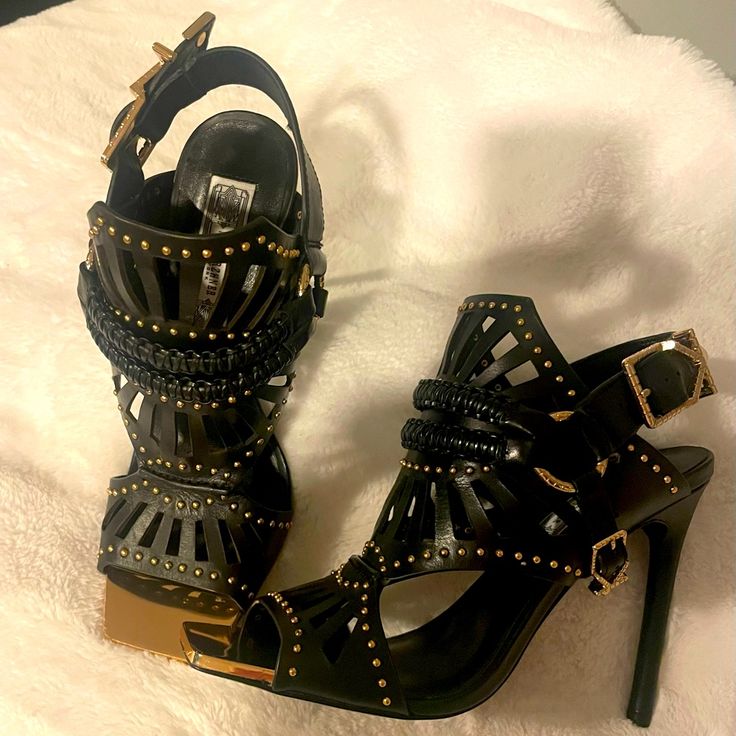 Beautiful Black Statement Heel With Gold Toned Studding. Nwot Size 7.5m Signature 18-Karat Gold-Plated Hardware Adds An Opulent Upgrade To A Studded, Laser-Cut Sandal Detailed With Handmade Rope Harness Straps. 4 1/2" Heel. Adjustable Strap With Slingback Closure. 18k Gold-Plated Hardware. Calfskin Leather Upper/Leather Lining And Sole. Studded Open Toe Leather Heels, Studded Leather Open Toe Heels, Leather Open Toe Heels With Studs, Designer Studded Open Toe Heels, Designer Open Toe Heels With Studs, Embellished Patent Leather High Heels, Studded Ankle Strap Heels For Evening, Evening Studs Ankle Strap Heels, Evening Ankle Strap Heels With Studs