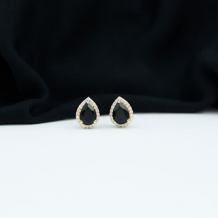 Product Details This Beautiful Teardrop Stud Earrings is embellished with Pear Cut Created Black Diamond as Solitaire and Diamond set in Halo. This Solitaire Stud Earring is Composed of Solid Gold. Product Information SKU SHP-EARRINGS0621101243 Length 9.2 mm Width 7 mm Height 4 mm Weight 1.36 gm (Approximate) LAB CREATED BLACK DIAMOND INFORMATION No.of Stones 2 Pieces Total Weight 1.50 Carat (Approximate) Dimension(approx) Pear-5X7 mm-2 Pcs Color Black Cut Brilliant Shape Pear Setting Type 3-Pro Black Onyx Earrings, Solitaire Studs, Halo Earrings Studs, Onyx Earrings, Signature Jewelry, Black Spinel, Timeless Jewelry, Diamond Set, Screw Back Earrings