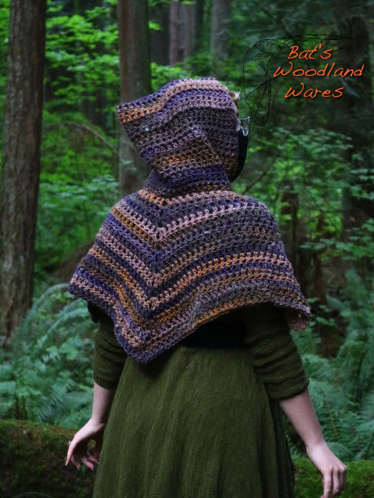 a woman wearing a crocheted shawl in the woods