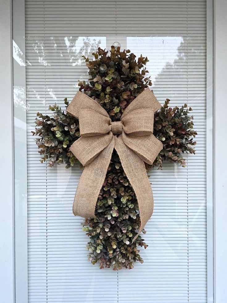 a wreath with a bow hanging on the front door