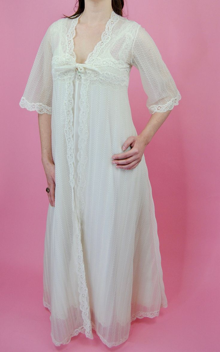 A perfect two- piece "bridal" or spring time night gown set made by "Eyeful by the Flaums". This gorgeous off-white  lace and nylon, set is sheer and breathable - perfect for the coming spring weather! The robe has 3/4 length sleeves, is relatively open size, and can tie in the front. The robe fabric is a mix of an intricate accordion-like pattern and lace, while the gown has lace and the pattern only on the bodice and hem. The night gown has an empire waist and is just a pull over- no zipper or Cream Lace Wedding Nightgown, Fitted Cream Nightgown For Wedding, Wedding Cream Lace Nightgown, Cream Wedding Night Gown With Lace Trim, Feminine Cream Wedding Gown, Delicate Lace Wedding Nightgown, Delicate Lace Nightgown For Weddings, Spring Wedding Gown With Delicate Lace, Feminine White Wedding Nightgown