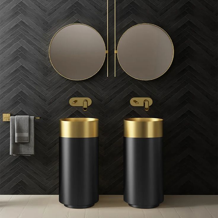 two black and gold pedestal sinks in a bathroom with mirrors on the wall above them