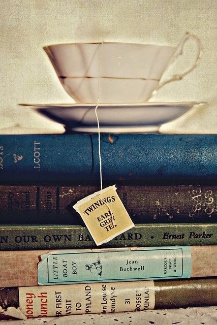 a stack of books with a tea cup on top