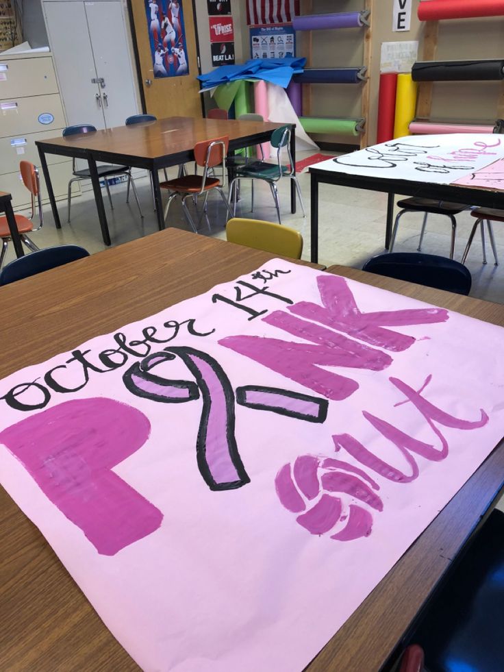 a pink sign that says college next to other desks