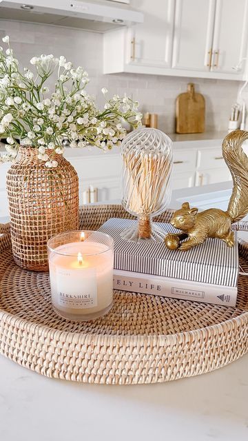 a tray with candles, books and flowers on it