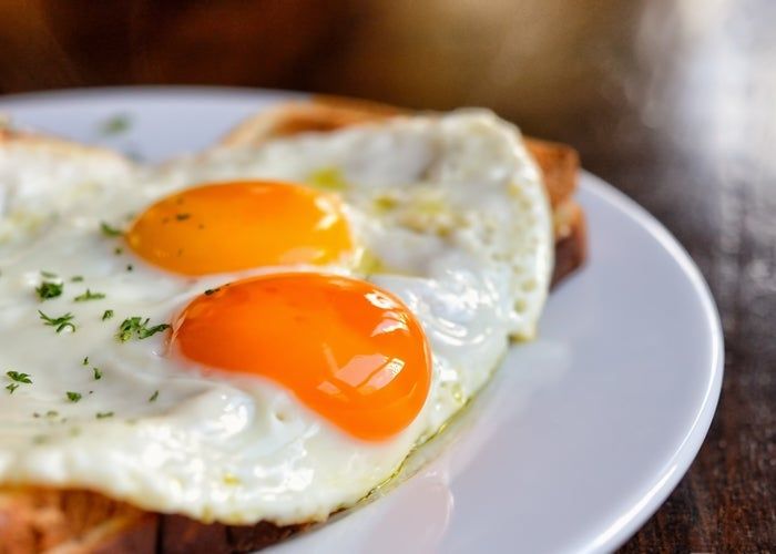 two fried eggs are on top of toast