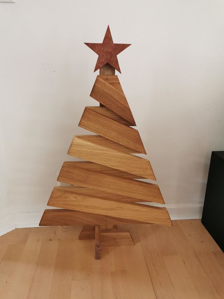 a small wooden christmas tree sitting on top of a hard wood floor