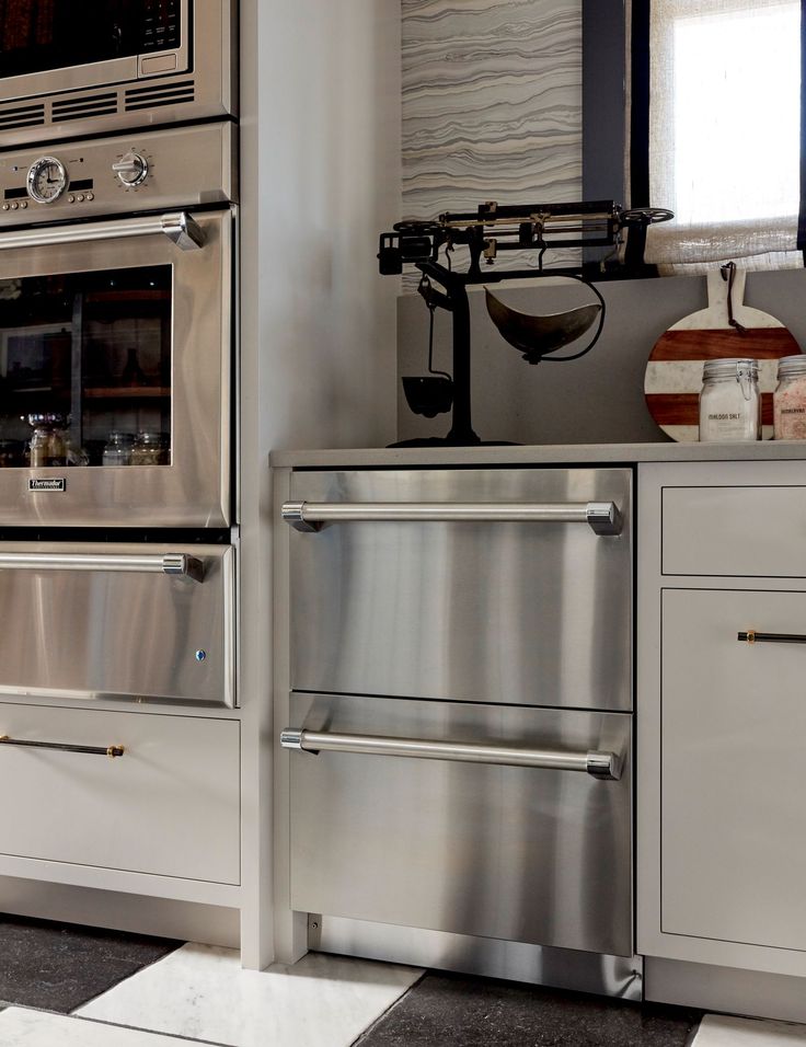 a kitchen with stainless steel appliances and checkered flooring