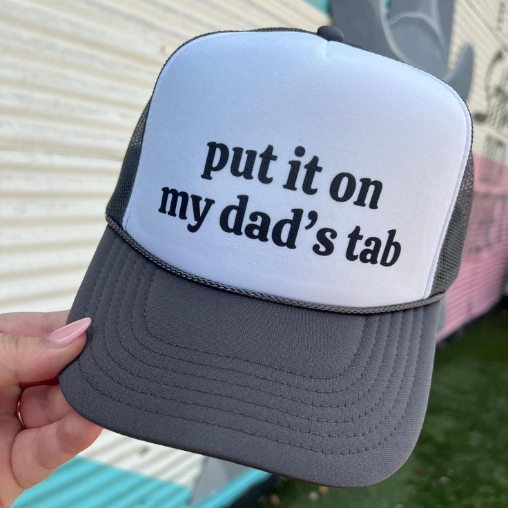 Get your hands on the On My Dad's Tab Trucker hat, the perfect accessory for any occasion. With its bold and witty slogan, "Put it on my dad's tab," this hat is sure to make a statement. Show off your sense of humor and relaxed style while also enjoying the practical benefits of sun protection. A must-have for any hat collection. Snap back Trucker Otto Snackback color: black Ships in 10 business days or sooner Adjustable Dad Hat With Letter Print In Trucker Style, Adjustable Trucker Dad Hat With Letter Print, Funny Snapback Cap With Letter Print, Funny Hats With Letter Print, Funny Trucker Hat With Letter Print And Curved Brim, Letter Print Baseball Cap For Father's Day, Father's Day Snapback Hat With Letter Print, Funny Hats With Letter Print As Gift, Father's Day Letter Print Adjustable Snapback Hat