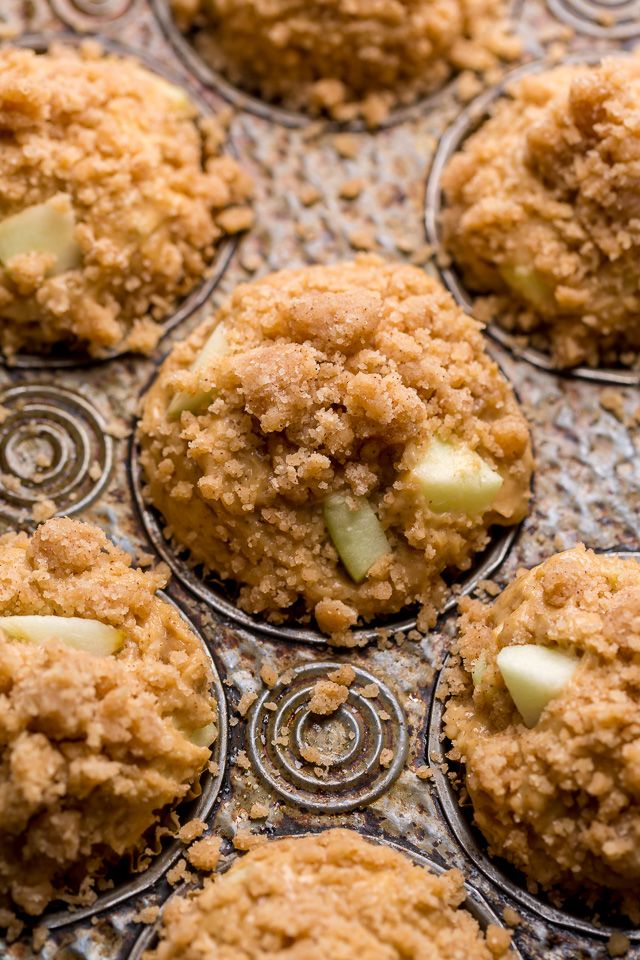 several muffins with apples are sitting on a cooling rack, ready to be eaten