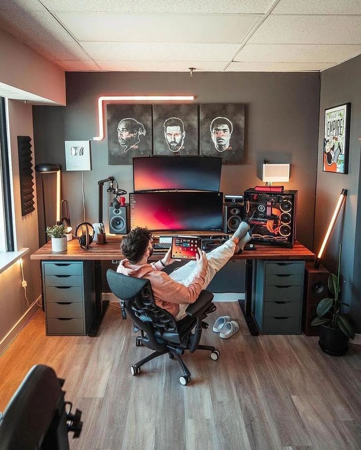 a man sitting at a desk with his feet up on the computer chair in front of him