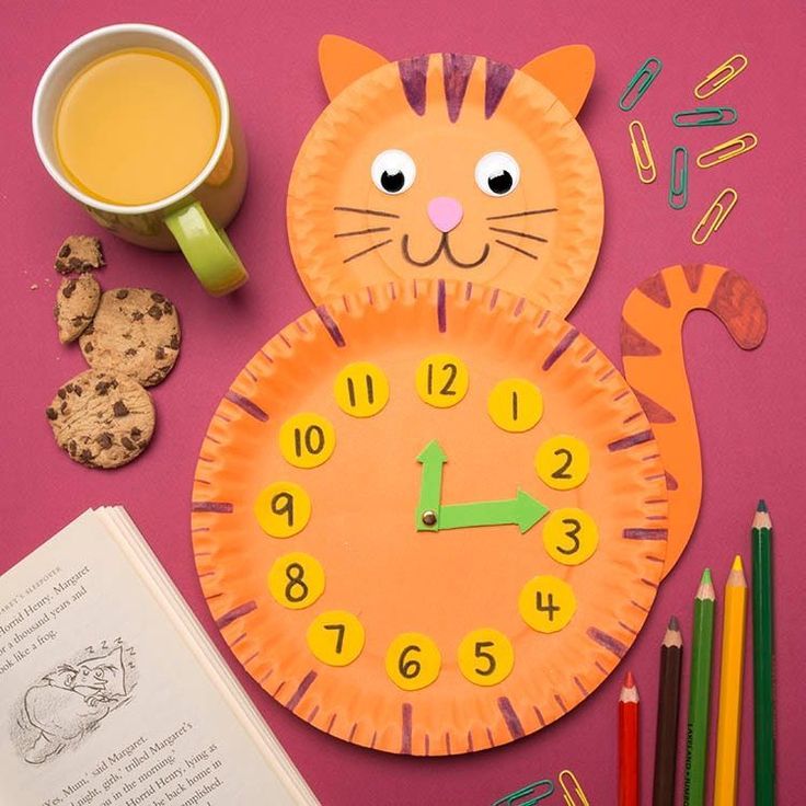 a clock made to look like a cat with numbers on it and a cup of coffee