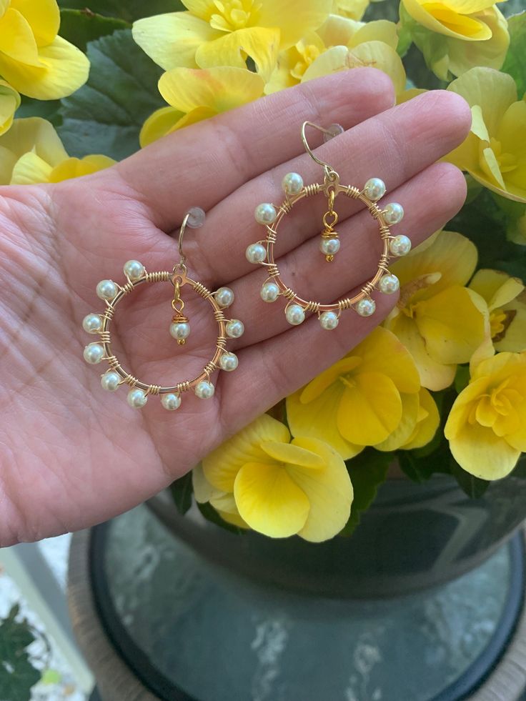 Handcrafted and carefully made 18K Gold plated hoops, wrapped with 18K gold plated wire, 14K Gold plated hooks and pearls.  These earring make a perfect gift for that special person. This pair of earrings is elegant and yet simple and minimalist.  Perfect for a casual outfit or elegant dress. Small enough to make them comfortable and noticeable to stand out.  Hoops are about 1 inch wide and about 1 1/2 inches from top of hook to bottom of hoop.  Made with high quality materials. For Hygienic reasons, NO returns allowed To make sure your earrings last long, please follow these instructions: -Remove jewelry before going to sleep -Remove jewelry before entering water or swimming -Remove before extensive sweating or when exercising -Wear your jewelry AFTER you have applied perfumes, hairspray Wedding Handmade Gold Plated Hoop Earrings, Gold Round Bridal Earrings With Ear Wire, Gold Drop Earrings For Wedding, Gold Hoop Bridal Earrings With Pearl Drop, Gold Plated Hoop Earrings With Ear Wire For Wedding, Handmade Gold Plated Hoop Earrings For Wedding, Handmade Gold Plated Wedding Hoop Earrings, Gold Wrap Drop Earrings For Wedding, Gold Hoop Pearl Earrings Nickel Free