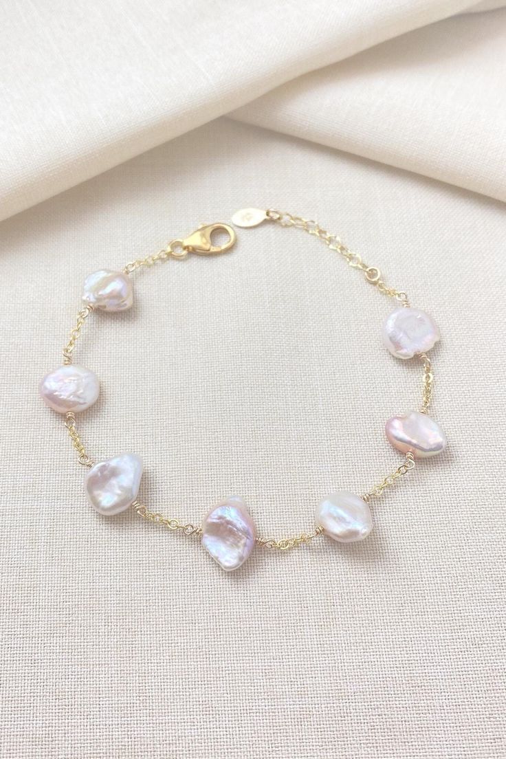 Pale pink keshi pearls adorn a shimmering gold-filled chain. These beautiful pearls each have a unique, organic shape, and the pink shades range from peach to mauve to light lavender. Bracelet length: 7.25-8.25 Materials: cultured freshwater keshi pearls GIFTING ~ Jewelry gift box included. ~ I am happy to ship directly to the recipient.  Enter their address during checkout. ~ If you would like a gift note included in the package, please leave the text of the note in the "Add a note to Marsh Creek Jewelry" message box at checkout. FREE SHIPPING ~ Orders ship within 2 business days. ~ Free shipping is First Class ~ Priority Mail and Express Shipping upgrades are available during checkout. RETURNS ~ Returns accepted within 30 days of delivery CARE ~ Polish metal components with a jewelry pol Delicate Baroque Pearl Bracelet With Pearl Chain, Delicate Baroque Pearl Chain Bracelet, Delicate Baroque Pearl Bracelet, High Luster Pearl Bracelet Gift, Elegant Pink Chain Bracelet With Adjustable Chain, Single Strand Baroque Pearl Bracelet As Gift, Rose Gold Baroque Pearl Jewelry For Wedding, Rose Gold Baroque Pearl Wedding Jewelry, Pink Pearl Drop Bracelet As Gift