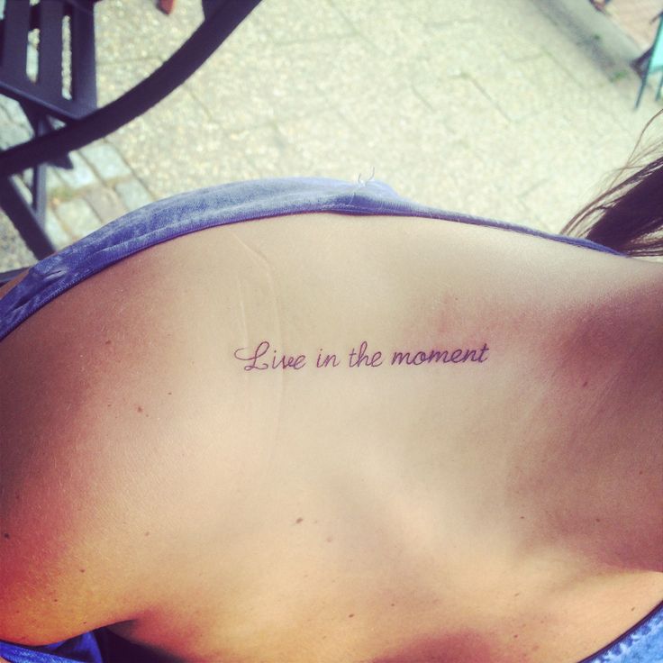 a woman with a tattoo saying live in the moment