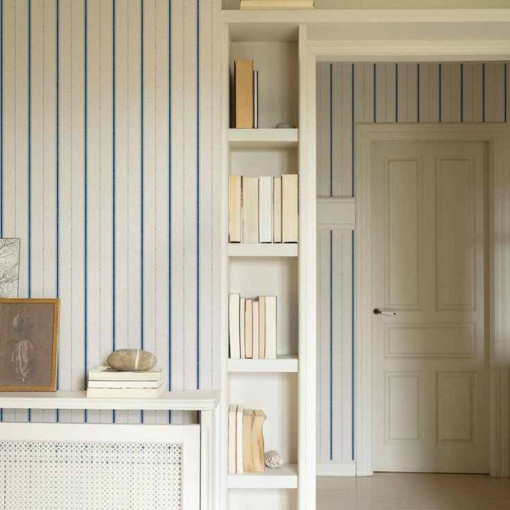 a bookshelf filled with lots of books next to a white door and window