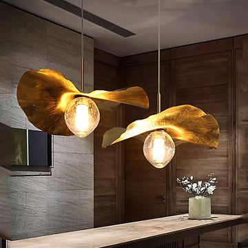 two lights hanging from the ceiling above a counter in a room with wooden paneling