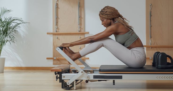 a woman is sitting on a rowing machine