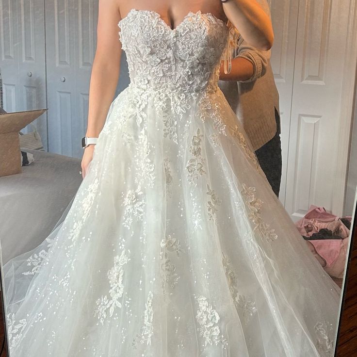 a woman taking a selfie in a wedding dress with her reflection in the mirror