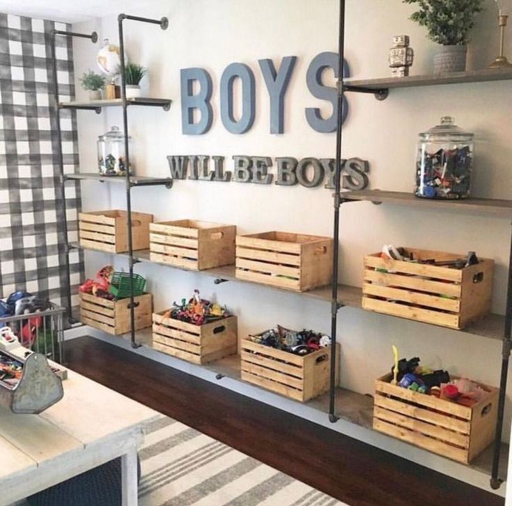 a room filled with lots of wooden boxes and shelves next to a wall mounted sign that says boys will be boys