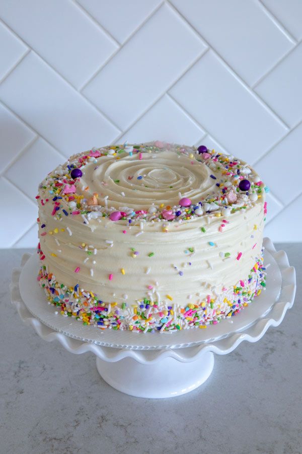 a cake with white frosting and sprinkles