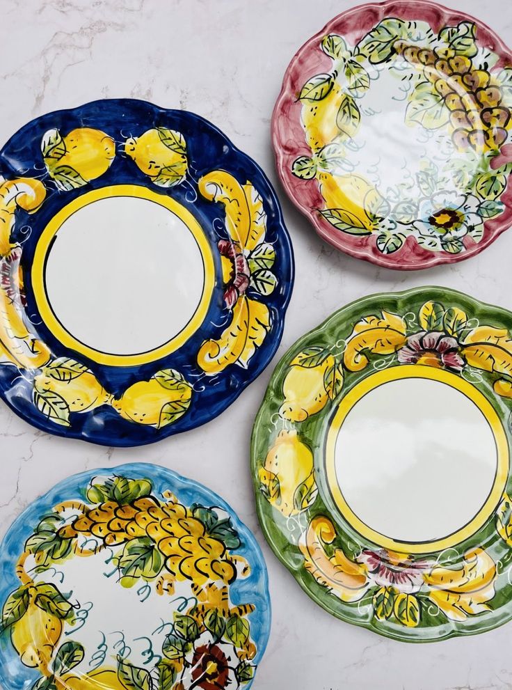 three plates with different designs on them sitting next to each other in front of a marble counter top