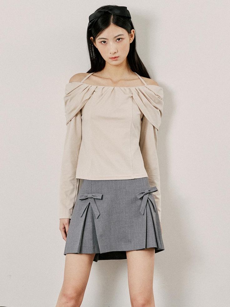 This is a structured A-line skirt featuring a textured fabric and a clean, seamless waistband. It is designed with two large, symmetrical bows on the front which add a playful yet sophisticated element to its style. The skirt has a discreet zipper closure at the back for a smooth fit. The overall design of the skirt combines a classic silhouette with a modern, decorative twist.- The bows provide a unique detail that enhances the skirt's aesthetic, offering both visual interest and a touch of femininity.- Its A-line cut is flattering for various body types, making it a versatile piece for different occasions.- The skirt's material and design suggest it could be a choice for professional settings as well as social events. Chic Mini Skirt With Bow Detail, Chic Mini Skirt With Bow, Flared Skirt With Bow Detail, Chic Bow Mini Skirt For Spring, Flared Skirt With Bow, Chic Bow Mini Skirt For Summer, Chic Summer Mini Skirt With Bow, Elegant Spring Mini Skirt With Bow, Chic Beige Flared Skort