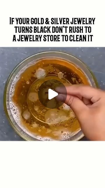 a person is touching the bottom of a glass bowl filled with liquid and other items